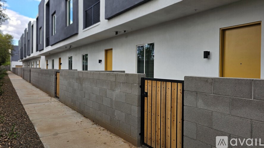 A row of houses with grey walls and yellow doors.
