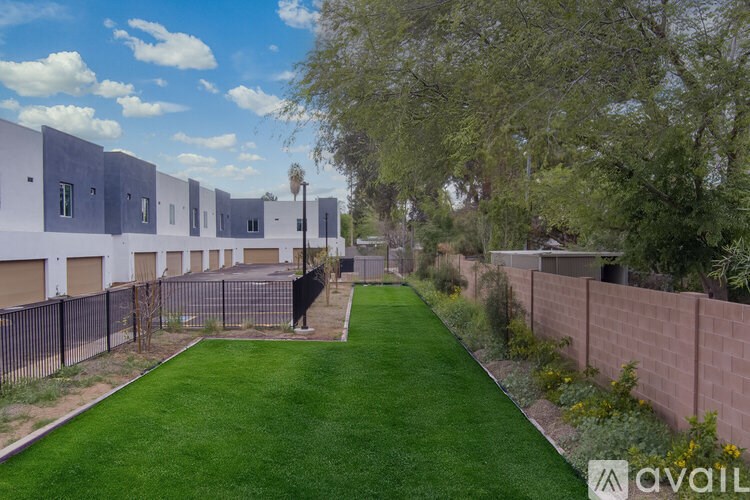 A row of houses with a green lawn in front.