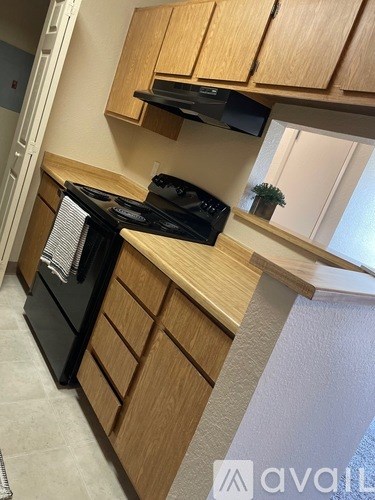 A kitchen with wooden cabinets and a black stove top oven.