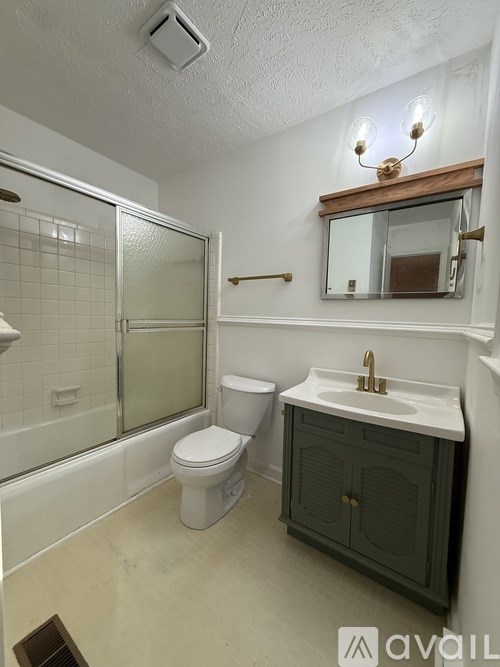 A bathroom with a toilet, sink, and shower.