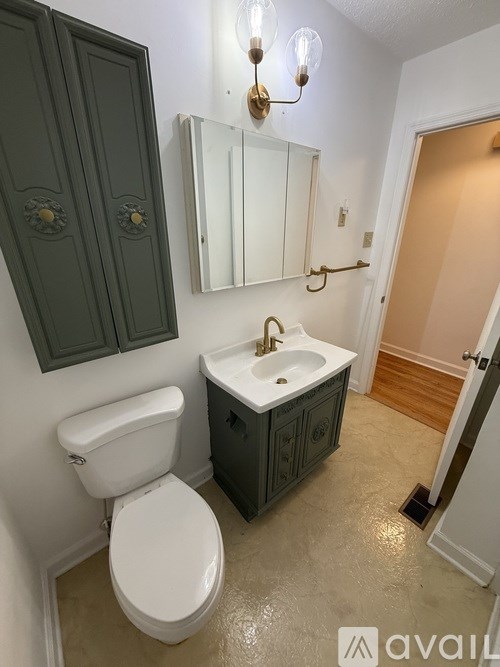 A bathroom with a toilet, sink, and medicine cabinet.