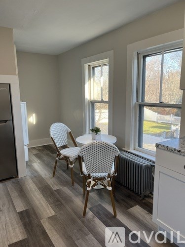 A kitchen with a table and chairs by a window.