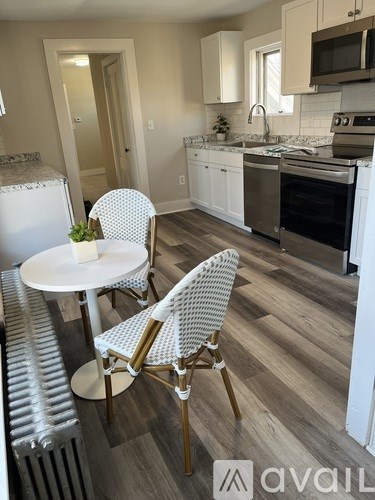 A kitchen with a table and chairs in the foreground.