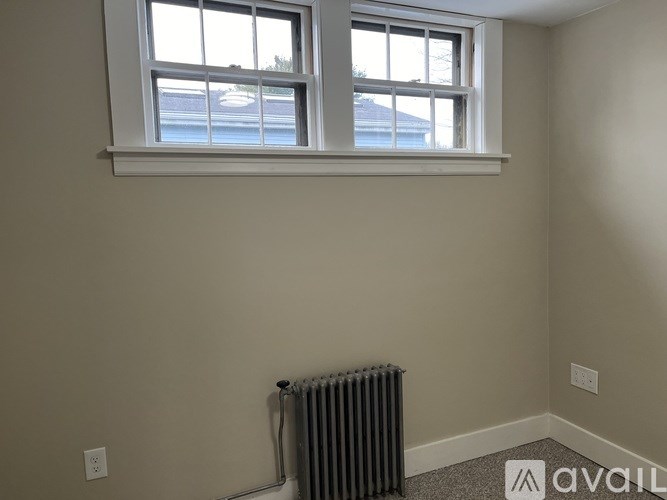 A room with a window and a radiator on the wall.