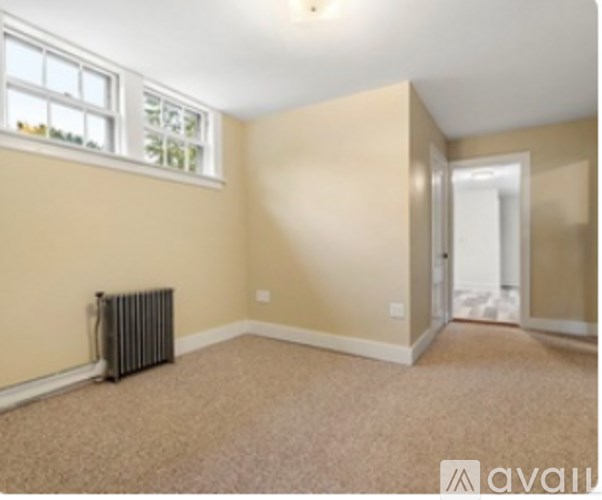 A room with a window and a radiator on the floor.