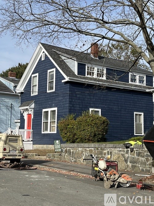 A blue house with white trim and a red door.