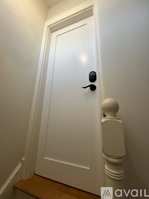 A white door with a black handle and a black lock.