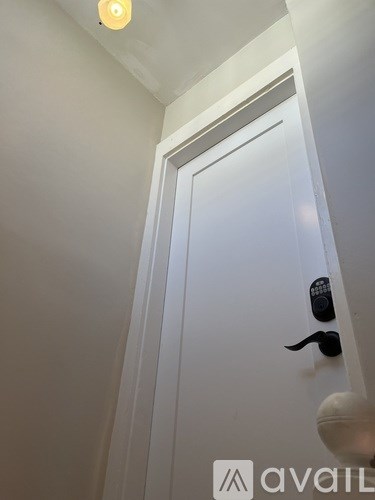 A white door with a black handle and a lock.
