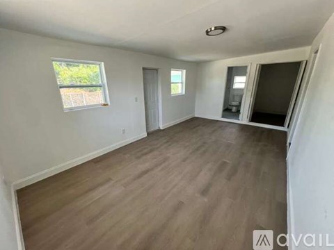 A room with wooden flooring and white walls is available for rent.