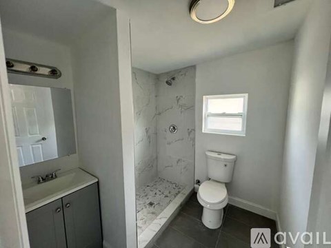 A bathroom with a toilet, sink, and marble tiles.