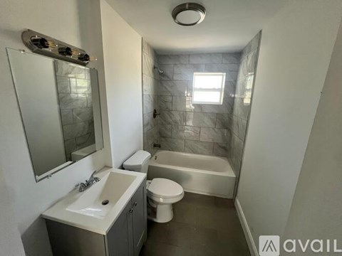 A bathroom with a toilet, sink, and bathtub.