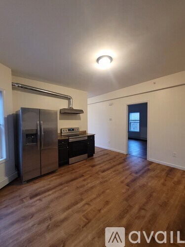 A kitchen with a refrigerator, stove, and sink.