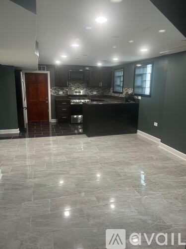 A kitchen with a black countertop and a wooden door.