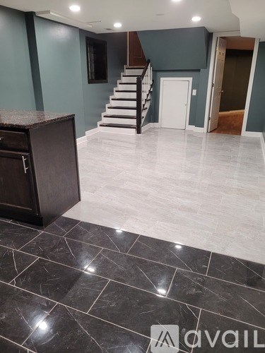 A room with a wooden door and grey walls.