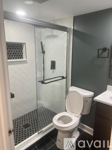 A white toilet in a bathroom with a glass shower door.