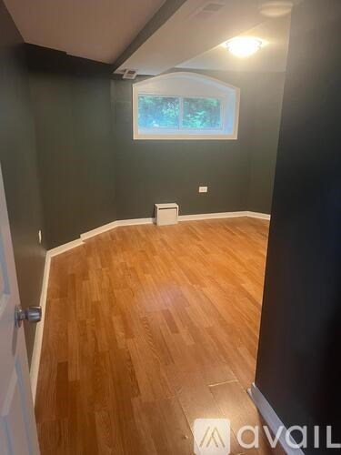 A room with wooden flooring and a window.