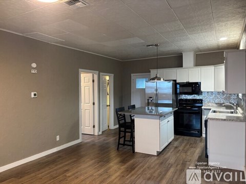 A kitchen with a black oven and white cabinets.