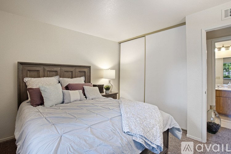 A bedroom with a large bed and a wooden headboard.