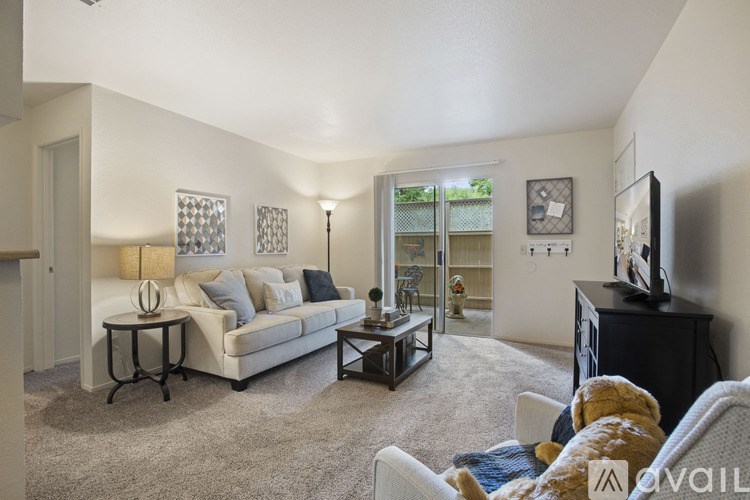 A living room with a white couch, a coffee table, and a flat screen TV.