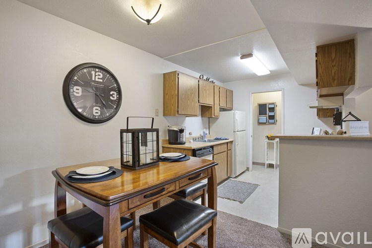A kitchen with a table and chairs and a clock on the wall.