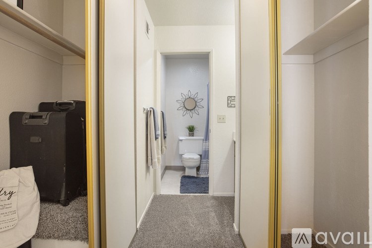 A bathroom with a toilet, sink, and mirror.