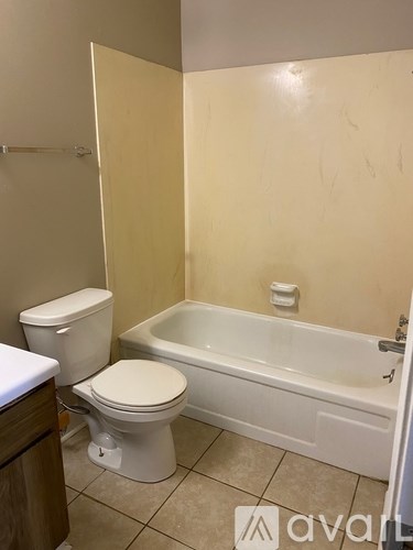 A white toilet and bathtub in a bathroom.