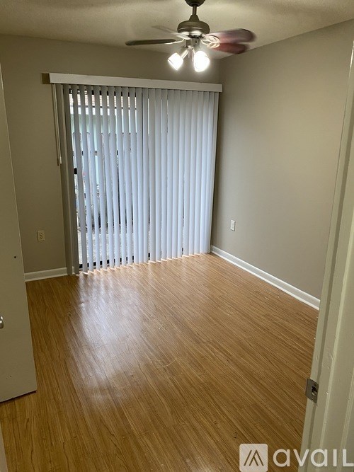 A room with wooden flooring and a ceiling fan.