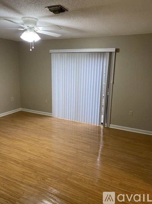 A room with wooden flooring and a ceiling fan.