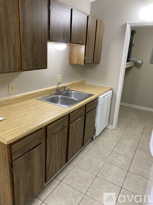 A kitchen with wooden cabinets and a white dishwasher.