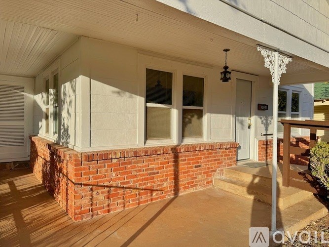 A house with a white exterior and a brick wall.