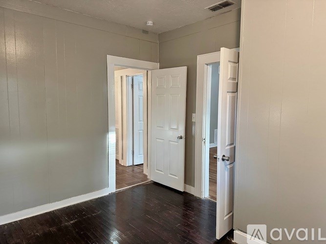 A room with white doors and wooden floors.