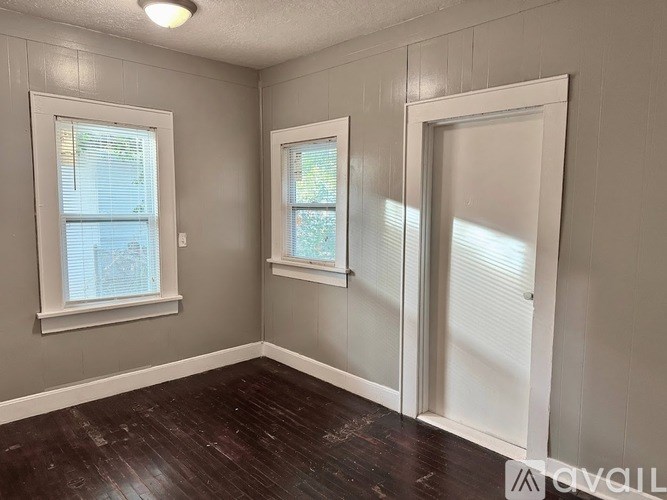 A room with two windows and a door.