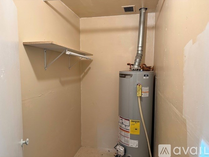 A small room with a heater and a shelf.