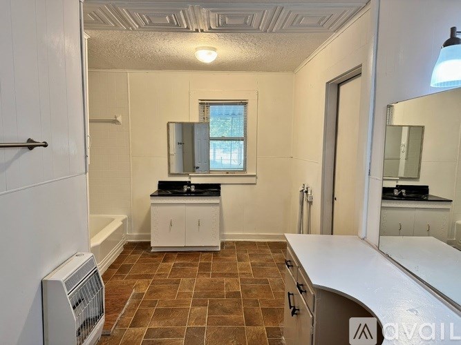 A bathroom with a brown tile floor and white walls.