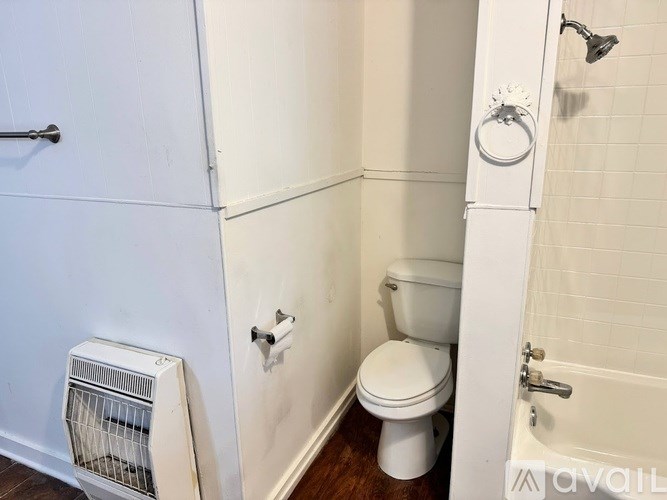 A white toilet in a small bathroom with a white door.
