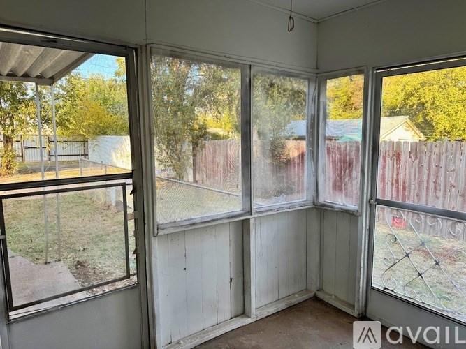 A room with a view of a backyard through large windows.