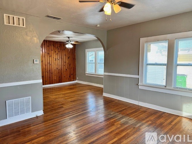 A room with wooden floors and a ceiling fan.