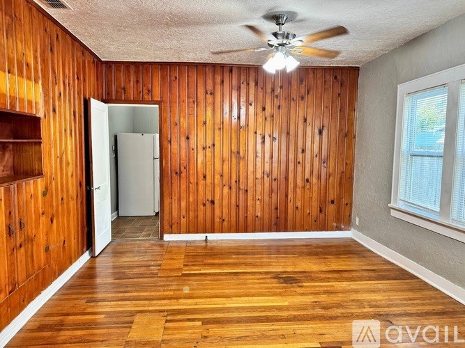 A room with wooden walls and a ceiling fan.