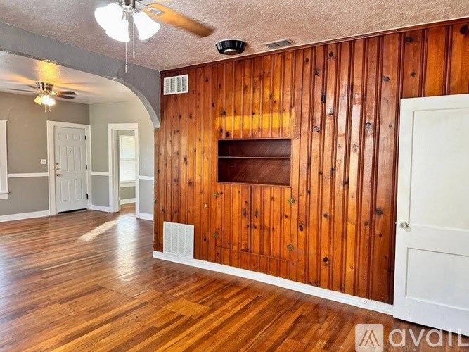 A room with wooden walls and a ceiling fan.