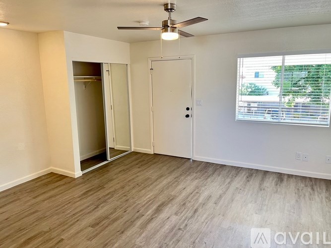 A room with a ceiling fan and a door leading to a balcony.
