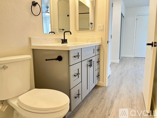 A white toilet sits next to a sink in a bathroom.
