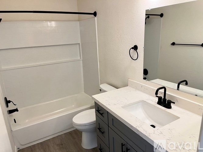 A white bathroom with a toilet, sink, and bathtub.