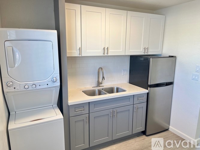 A kitchen with a white oven, sink, and cabinets.