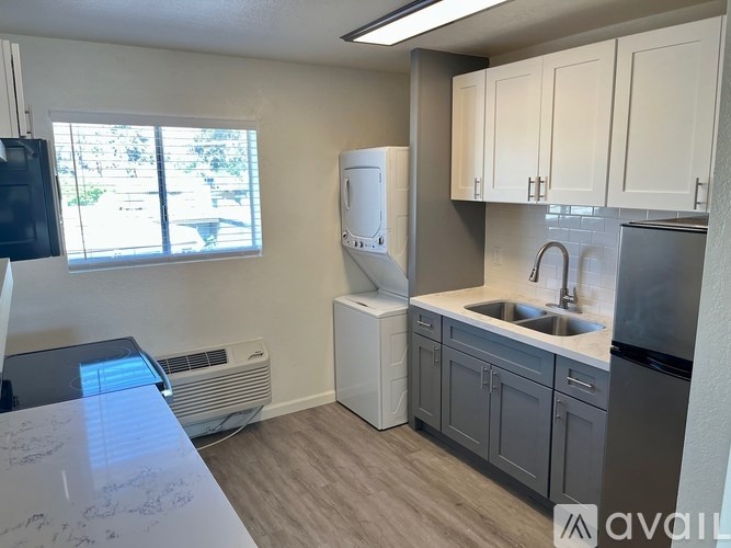A kitchen with a white fridge, sink, and cabinets.