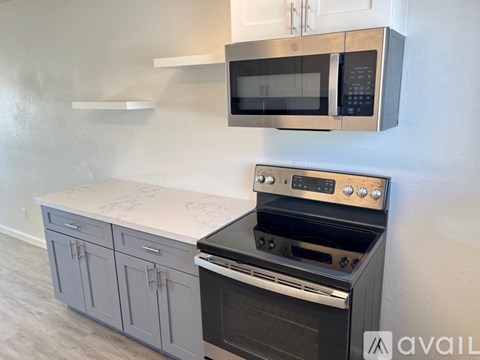 A kitchen with a stove and microwave above it.