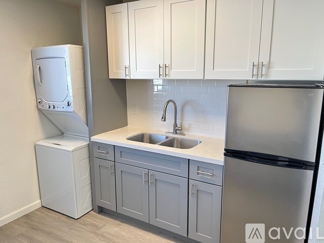 A kitchen with a sink, a refrigerator, and a dishwasher.