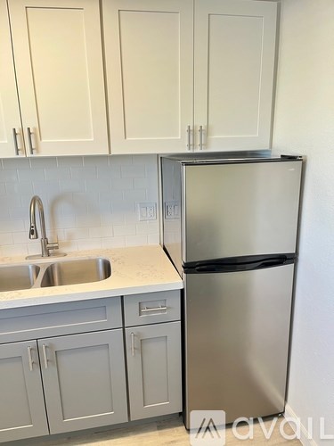 A kitchen with a sink and a refrigerator.