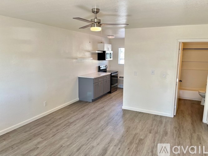 A room with a ceiling fan and a cabinet.