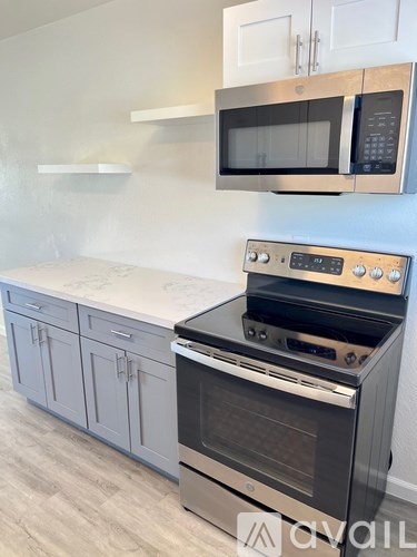 A kitchen with a stove top oven and microwave above it.