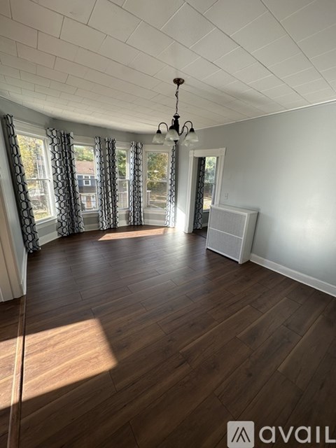 A room with wooden floors and a chandelier.